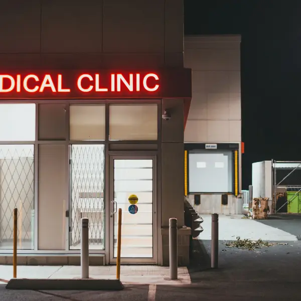 Medical clinic entrance at night with an illuminated red sign