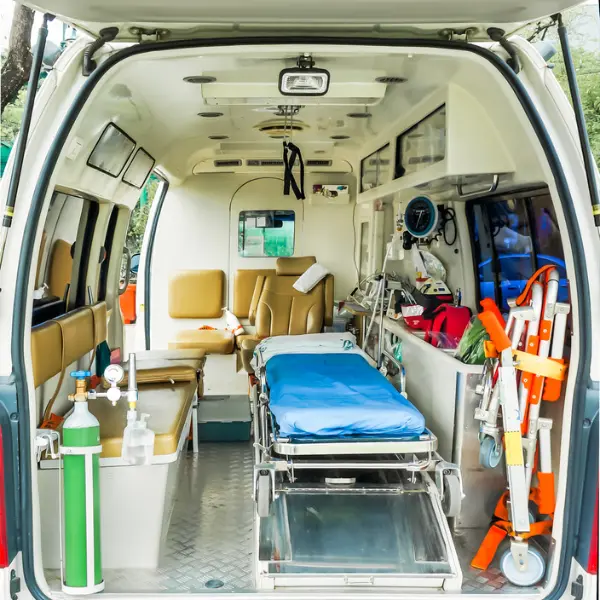Interior of a medical transport van with a stretcher, passenger seating, and visible medical equipment