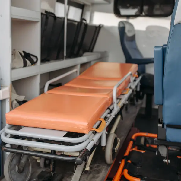 Orange-padded stretcher inside the rear of a patient transport vehicle