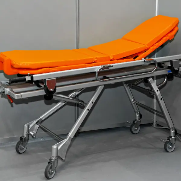Orange padded adjustable medical transport stretcher on a wheeled metal frame